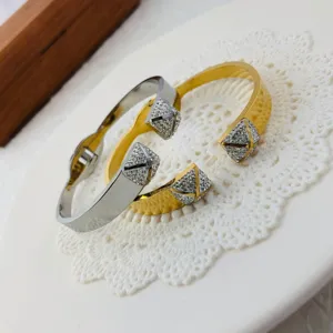 Elegant stainless steel wide cuff bangle with sparkling crystal pyramid ends in gold and silver