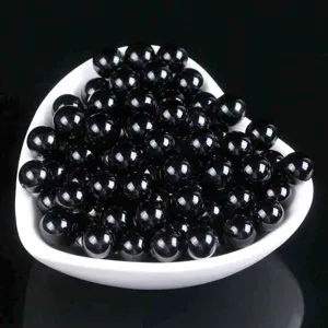 Black obsidian loose beads detail shot, smooth round stone beads for DIY jewelry making.