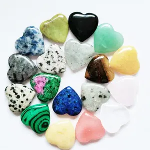 Detailed view of assorted natural crystal heart stones, colorful polished gemstone palm stones.