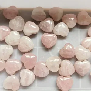 Vue détaillée de pierres de cœur en quartz rose poli, cristaux de guérison pour bricolage.