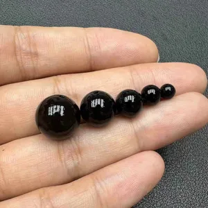 Close-up detail of natural black obsidian round loose beads in gradient sizes for jewelry making.