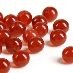 Closeup of natural red agate round loose beads, glossy polished surface for DIY jewelry making.