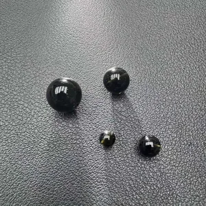 Close-up detail of natural black obsidian loose beads, smooth round gemstone accessory for DIY.