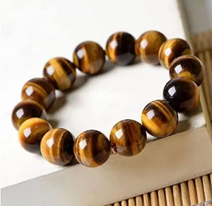 Natural yellow tiger's eye stone beaded bracelet gemstone jewelry detail close-up shot style.