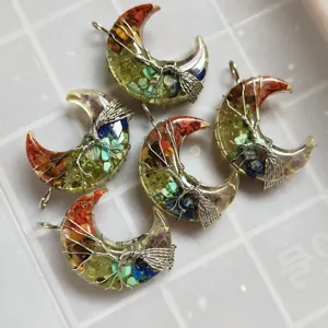 Vue détaillée de pendentifs croissant de lune en cristal enroulé de fil fait main.