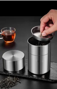 Stainless steel tea canister detail view, brushed finish metal storage jar for kitchen food preservation.