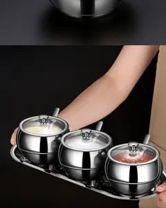 Premium stainless steel seasoning jar set with glass lids and spoons on a metal tray