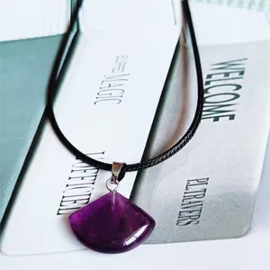 Gedetailleerd uitzicht van natuurlijke amethist hanger met paarse steen en zwart koord.