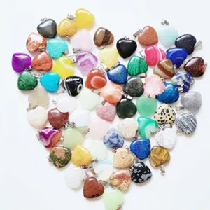 Large collection of colorful heart-shaped stone pendants arranged in a heart pattern