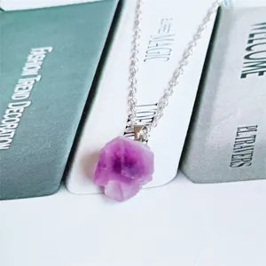 Gedetailleerd close-up uitzicht van natuurlijke amethist kristal hanger halsketting.