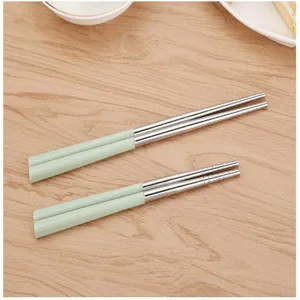 Bacchette in acciaio inossidabile con manici verde chiaro e dettagli antiscivolo.