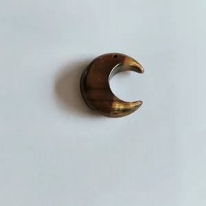 Détail d'un pendentif en forme de croissant de lune en pierre œil de tigre naturelle