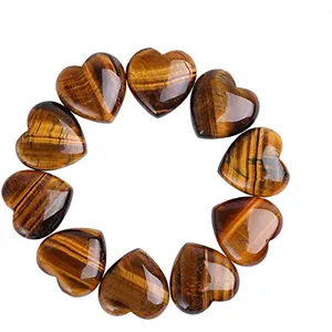 Detailed view of polished tiger eye heart shaped crystal gemstone, smooth surface and shiny luster.