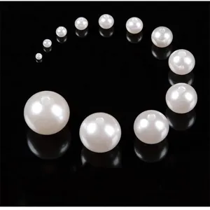 Detail view of white ABS imitation pearl loose beads in various sizes for DIY jewelry making.