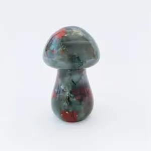 Natural crystal gemstone mushroom carving detail view, unique green red patterned stone art.