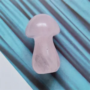 Closeup detail view of a natural rose quartz crystal mushroom carving ornament for healing decor.