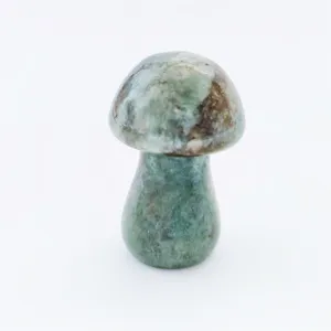 Close-up detail of natural green crystal carved mushroom stone ornament, polished smooth.