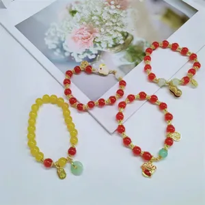 Ensemble de bracelets en perles style chinois, cristaux rouges et jaunes avec breloques dorées.