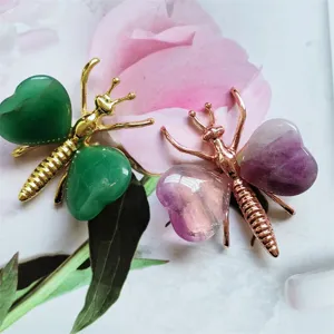 Close-up detail of natural crystal butterfly ornaments featuring heart-shaped gemstone wings and metal.