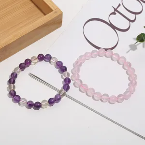 Natural crystal gemstone bead bracelets featuring purple amethyst and pink rose quartz stones.