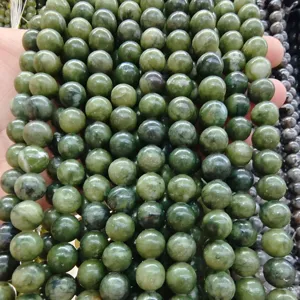 Primo piano di perline rotonde in pietra di giada verde in fili, ideali per gioielli fai da te.