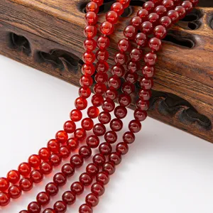 Detailed shot of smooth red agate gemstone round bead strands for DIY jewelry making.