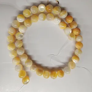Close-up of natural yellow mother of pearl shell loose beads for DIY jewelry making.