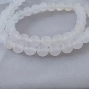 Close-up detail of smooth natural white agate round beads for DIY jewelry making and crafting.