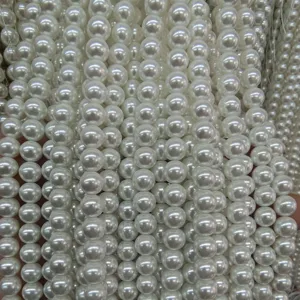 Vista detallada de cuentas de perlas blancas, ideal para pulseras y collares de bricolaje.