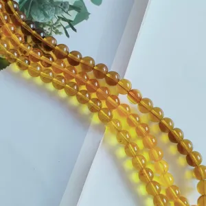 Close-up detail of smooth amber glass round loose beads for DIY handmade jewelry accessories.