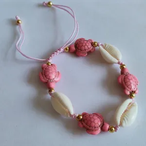 Handmade pink turtle shell bracelet detail, boho beach style adjustable woven cord jewelry.
