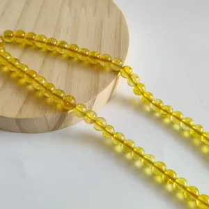 Yellow glass round beads detail shot, perfect for DIY handmade jewelry and craft accessories.