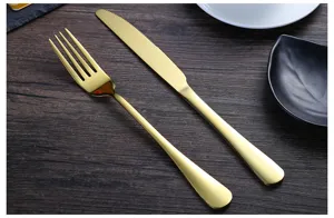 Juego de cubiertos de acero inoxidable dorado con cuchillo para carne y tenedor.