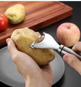 Pelador de patatas de acero inoxidable detalle, hoja ancha herramienta cocina fruta.