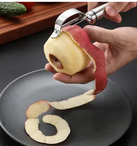 Detalle de pelador de patatas de acero inoxidable, herramienta de cocina afilada para frutas.