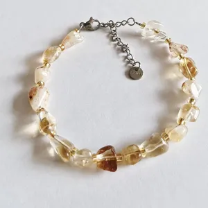 Detailed view of natural irregular crystal gemstone beaded bracelet with steel chain extension.