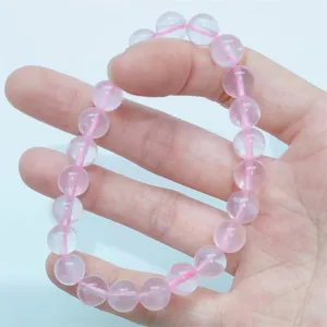 Close-up detail of natural pink crystal beaded bracelet, elegant and smooth gemstone surface.