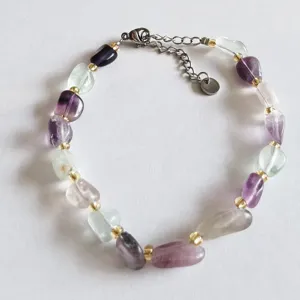 Natural irregular crystal gemstone bracelet detail shot featuring shiny gold spacer beads.