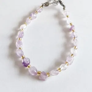 Natural irregular crystal chip bracelet detail view showing purple and clear quartz beads with gold