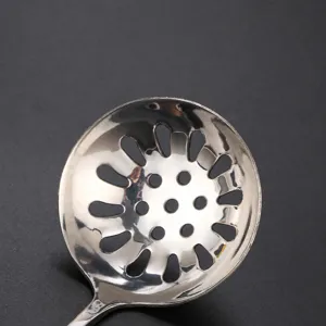 Stainless steel slotted soup spoon with even drainage holes, durable kitchen skimmer for home use.