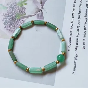 Green rectangle bar and gold bead bracelet detail shot, elegant fashion energy hand jewelry.