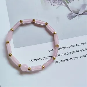 Detailed close-up of natural rose quartz long block beads bracelet with gold spacer beads.