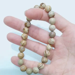 Close-up detail of natural stone round bead single circle bracelet showing smooth texture and grains.