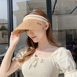 Dettaglio visiera da sole estiva in paglia intrecciata da donna, cappello vuoto casual.
