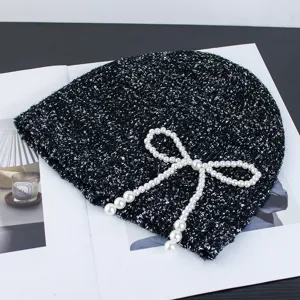 Black sequin knit beanie hat with elegant pearl bow decoration for autumn and winter fashion.