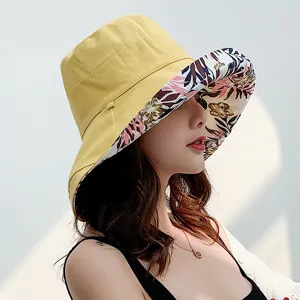 Detailed view of women's reversible bucket hat, featuring a wide floral brim and solid yellow side.
