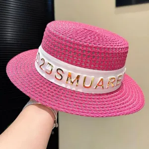 Cappello di paglia rosa con nastro bianco e lettere dorate, perfetto per la spiaggia e l'estate.
