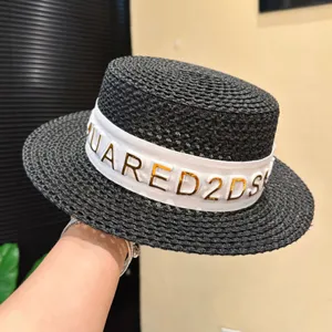 Cappello di paglia estivo con tetto piatto nero e nastro di lettere bianche per vacanze al mare.