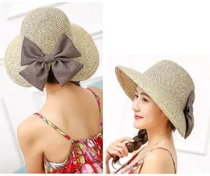 Women summer straw sun hat with brown bow, foldable UV protection beach cap detail view.