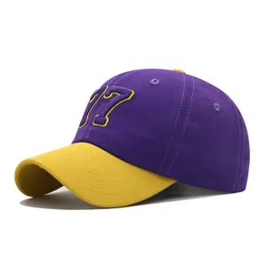 Close-up detail shot of purple and yellow contrast baseball cap featuring embroidered number 17.